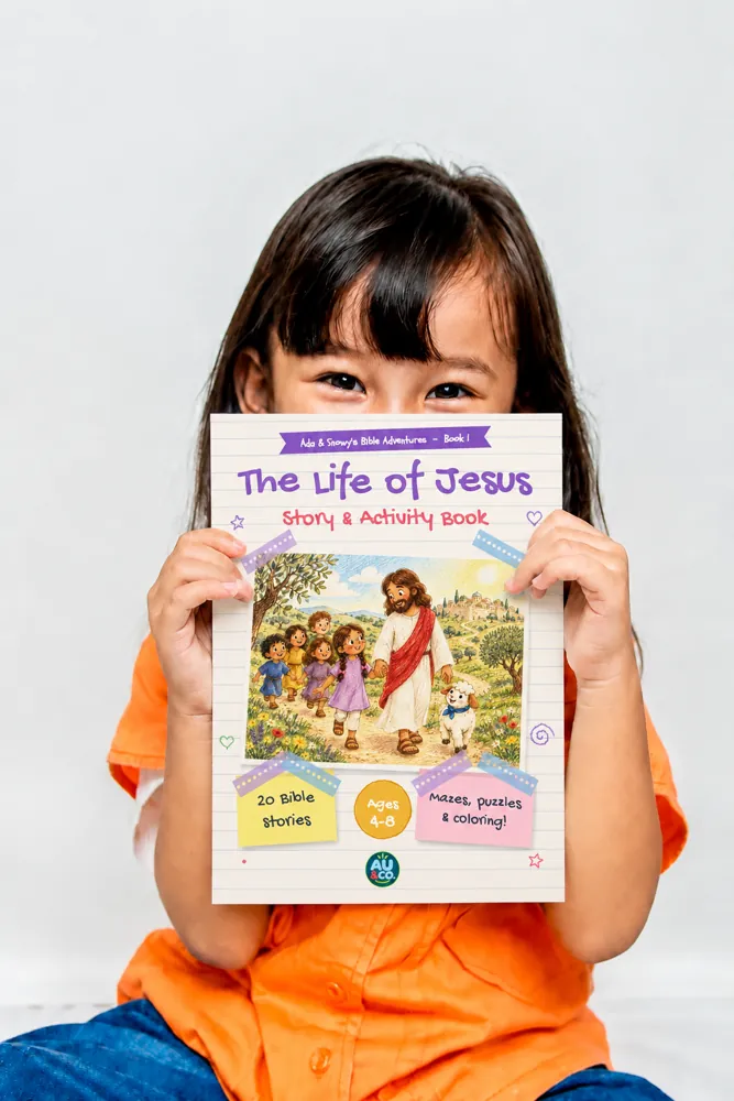 A girl holding up Ada & Snowy's Bible Adventures, Book 1: The Life of Jesus